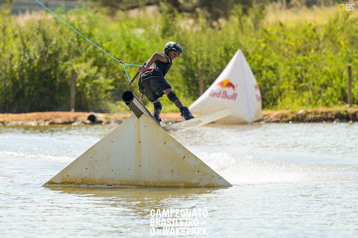 Criança praticando wakeboard em cima de um kicker